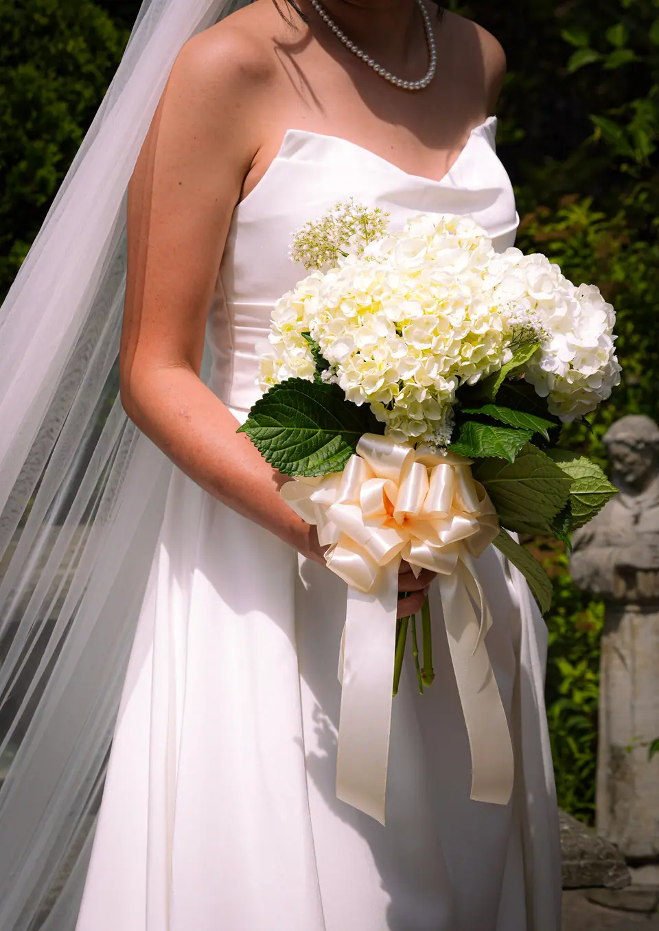 A bride holding a white and pale blue hydrangea bouquet