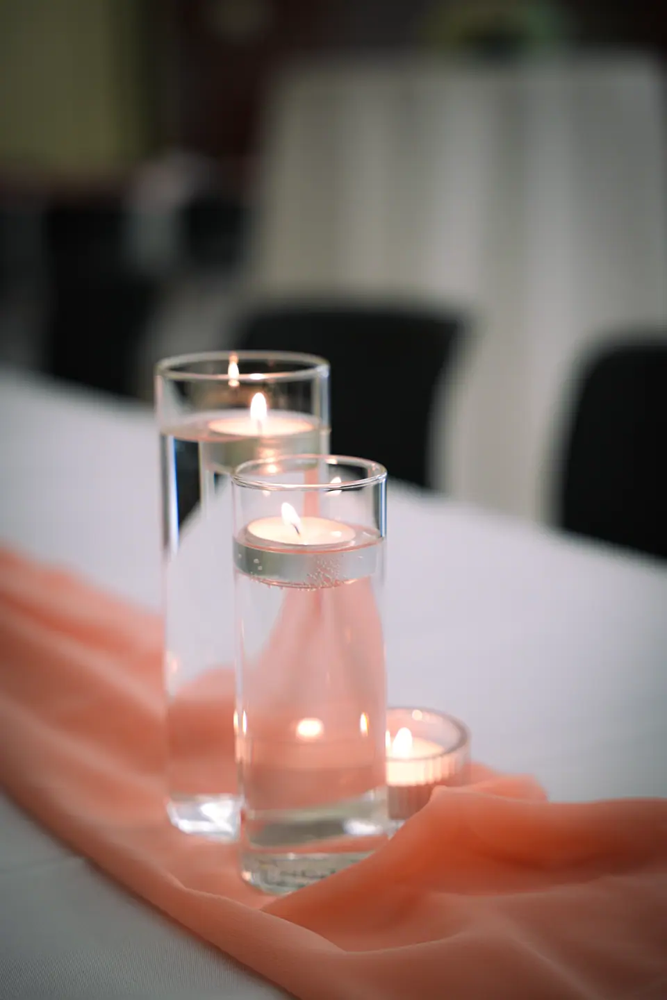 Floating candles glowing in clear glass vessels