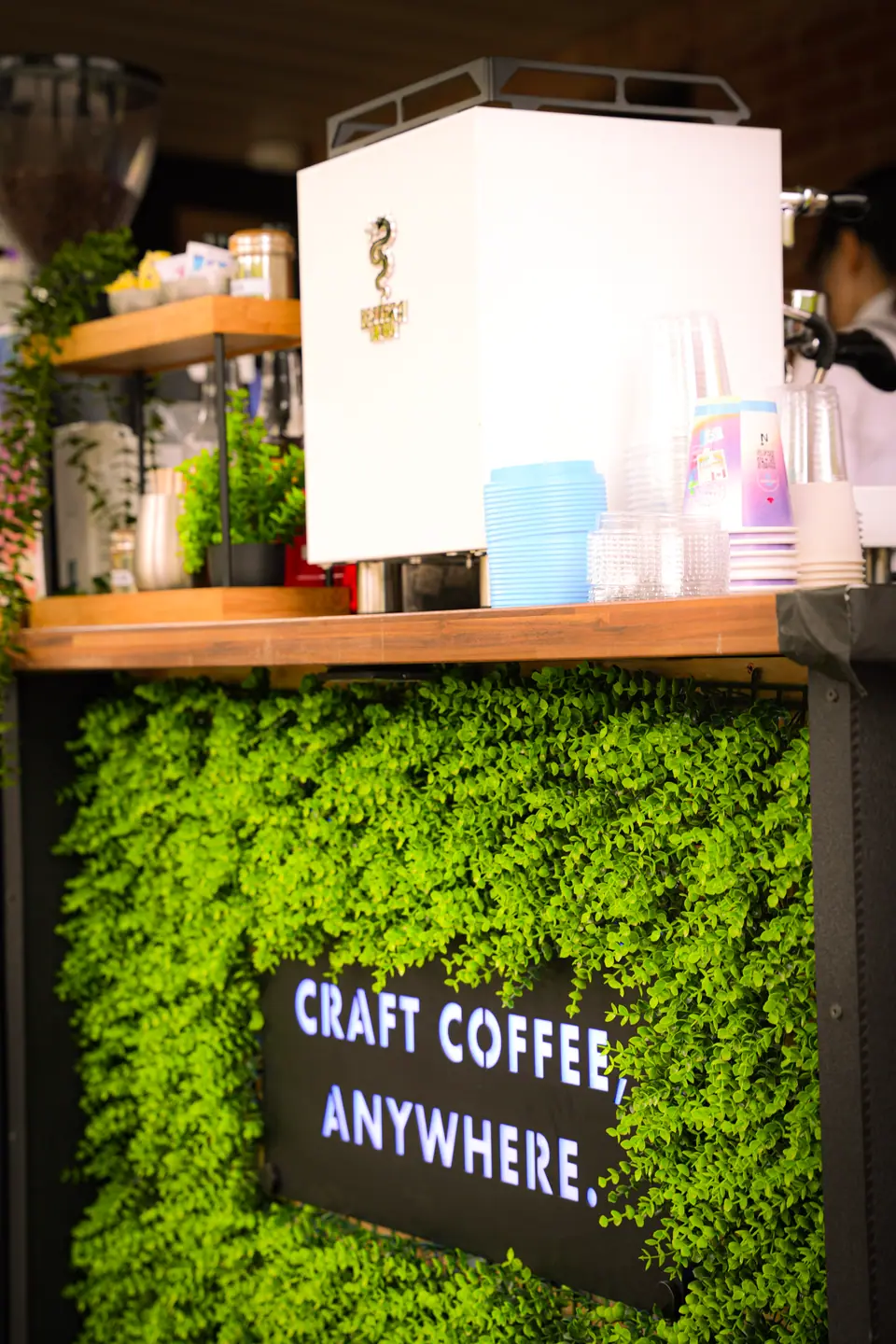 The reception bar framed with a wall of greenery