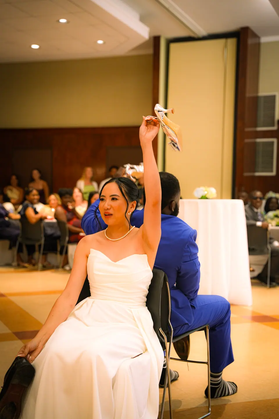 The bride lifting her bouquet above the dance floor