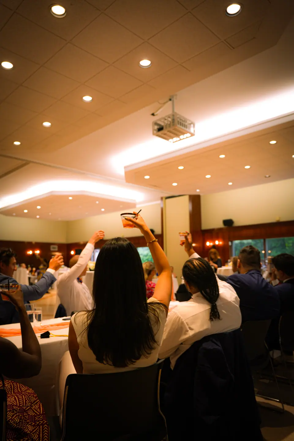 Guests dancing together beneath the reception lights