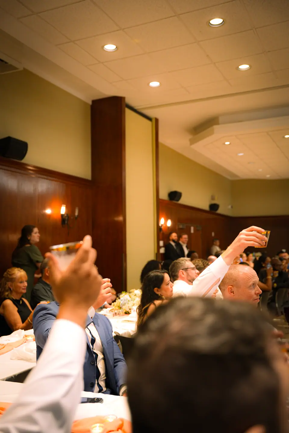 A toast raised across a warm evening reception room