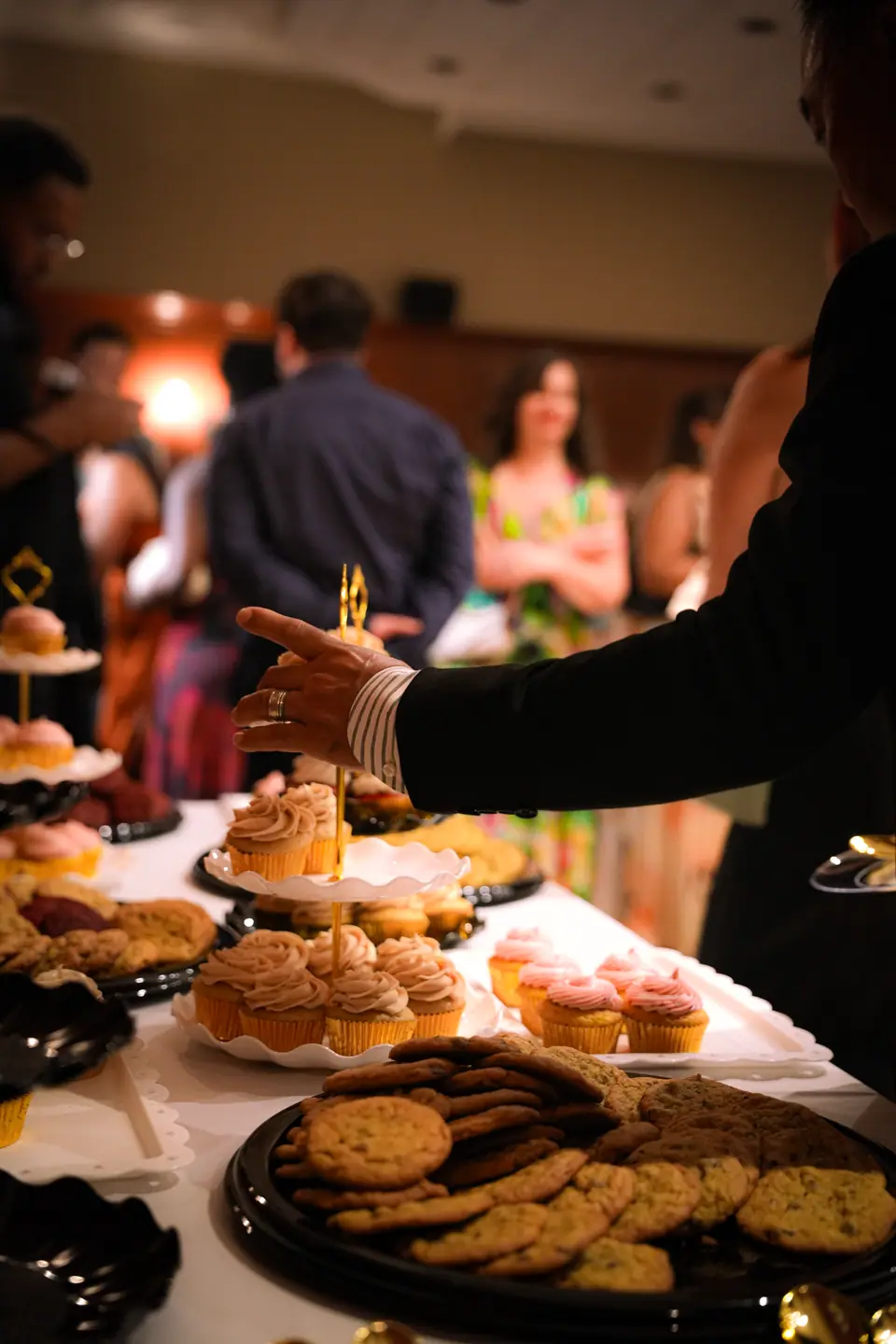 Guests choosing desserts from the wedding table
